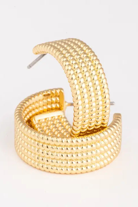 Gold hoop earrings on a light gray background