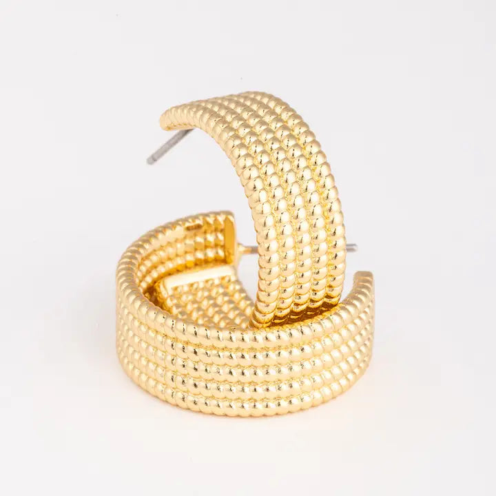 Gold hoop earrings on a light gray background